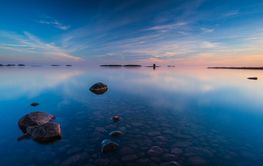 Stillness of Lake Vanern reflects a stunning sunset in...