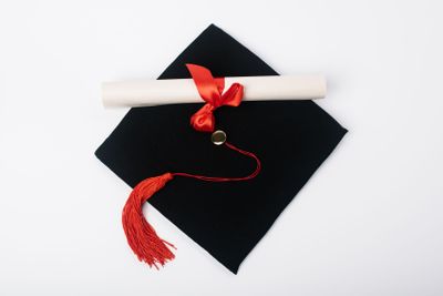 Top view of black graduation cap with red tassel and...