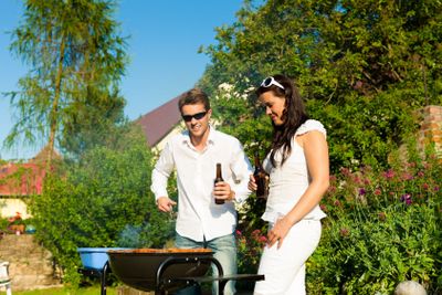 Couple doing BBQ in garden during summer