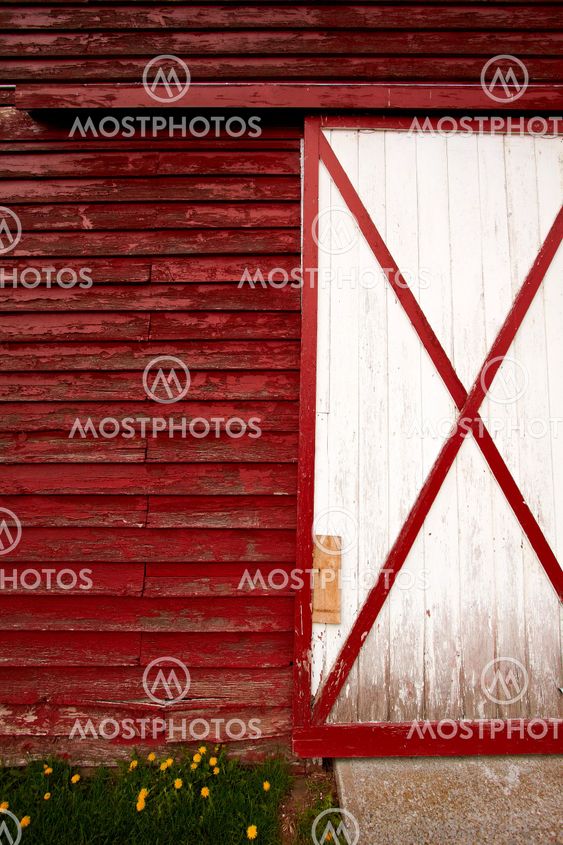 Wall and the door on the old red barn in the countryside.
