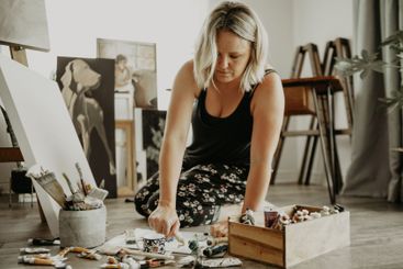 Painter, studio and woman with canvas on floor with...