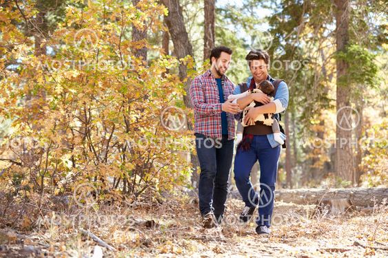 Gay Male Couple With Baby Walking Through Fall Woodland