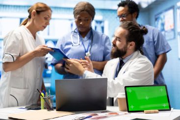 Doctors and nurses review radiography scans with a green...
