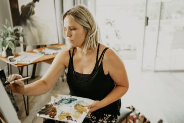 Art, focus and painting, woman in studio at home with...