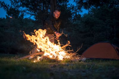 Man lights a fire in the fireplace in nature