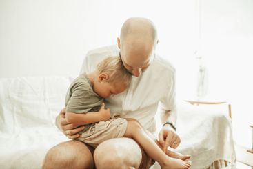 Dad, kid and sitting on lap in home for love, care and...