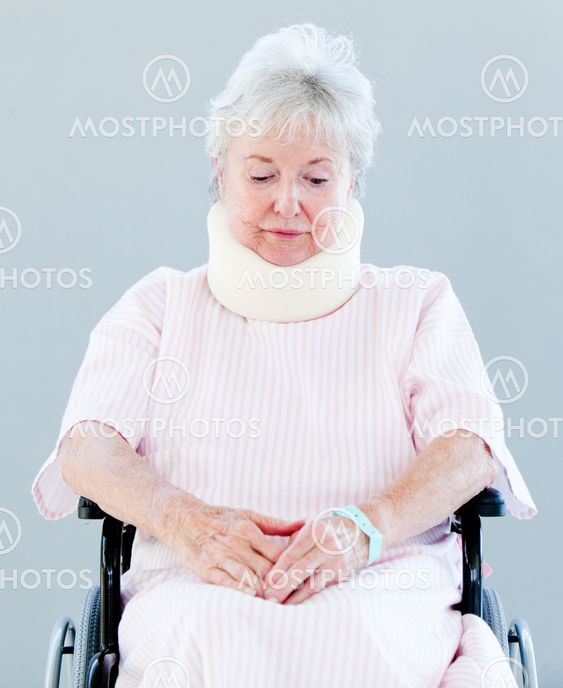 Upset senior woman with a neck brace sitting on a wheelchair