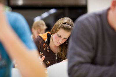 pretty, female college student sitting in a classroom...