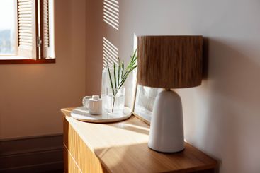 A wooden chest of drawers in the bedroom and an open...