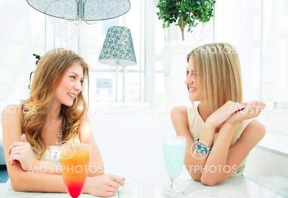 two beautiful women chatting in a cafe