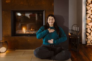 Woman with eyes closed doing breathing exercise while...