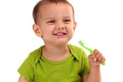 Cute little boy brushing teeth, isolated on white