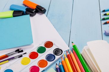 Bright and colorful art supplies arranged on a blue...