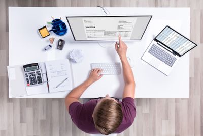 Businessman Checking Invoice On Laptop