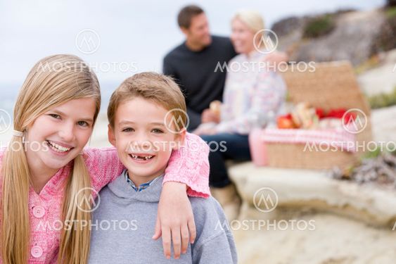 Family at beach with picnic smiling
