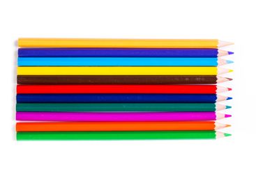 Colorful assortment of art pencils arranged in a row on...