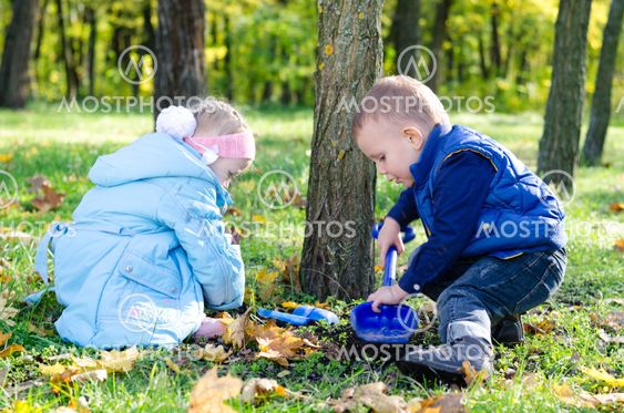 Brother ans sister digging with a trowel