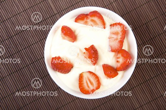 strawberries with cream on bamboo tablecloth