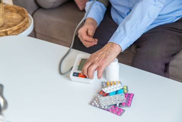An old woman measures her blood pressure. Selective focus.