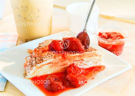 cheese crepe with sweet strawberry topping ready to eat with cool coffee background