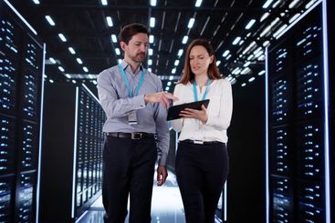 Engineers in data center server room configuring AI...