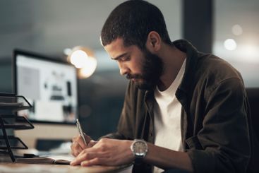 Writing, creative and man in office, night and employee...