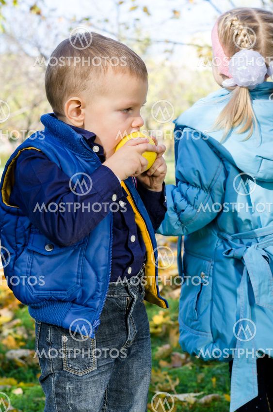 Cute little boy biting an apple