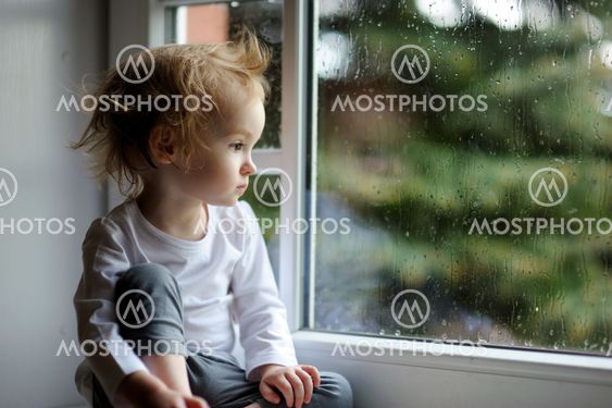 Adorable toddler girl looking though the window