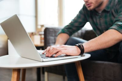 Cropped image of man with laptop by the table