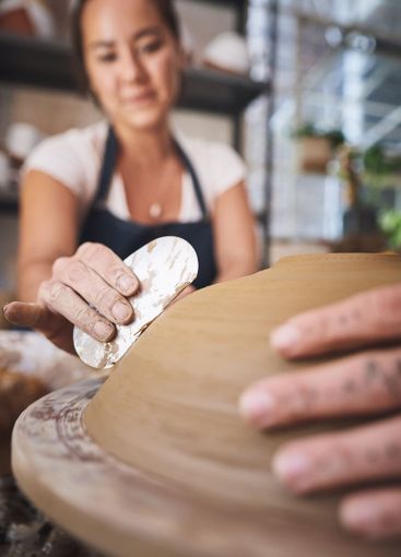 People, hands and pottery class for molding, working...