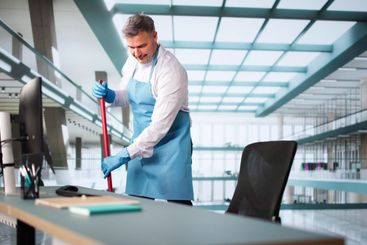 Male Janitor Cleaning Floor With Mop