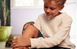 Young boy interacts with his pet leopard gecko in a...