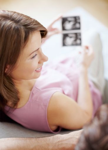 Woman, home and smile for pregnancy with scan of baby...