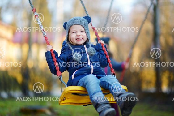 Adorable girl having fun on a swing