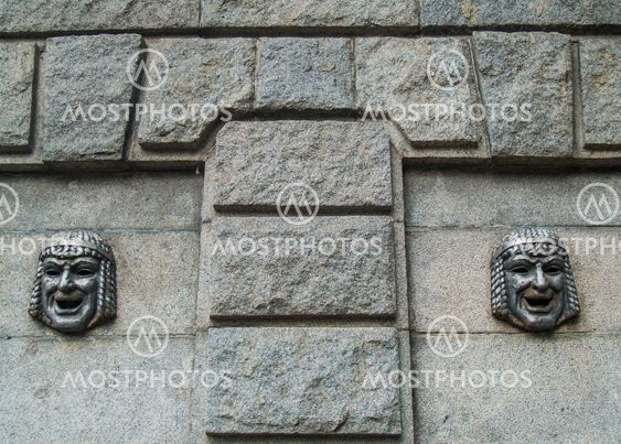 Theatrical mask on a granite wall