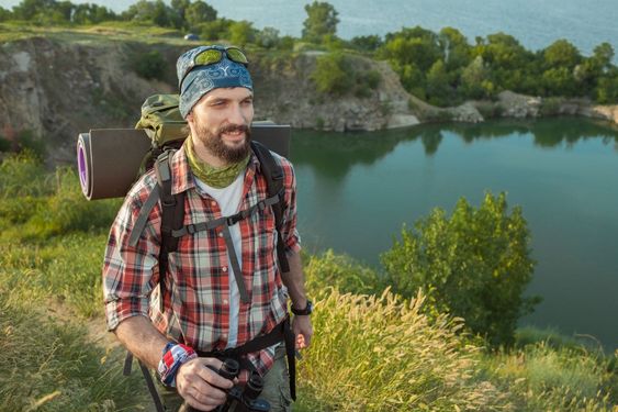 Young caucasian man with backpack walking on the top of...