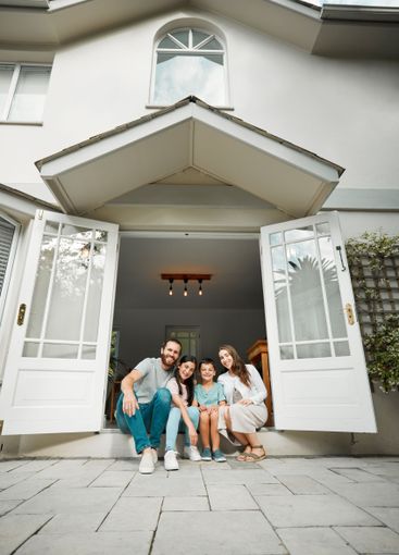 Parents, kids and happy in new home for portrait, real...