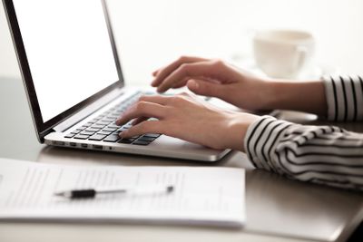 Close up view of female hands typing on laptop keyboard