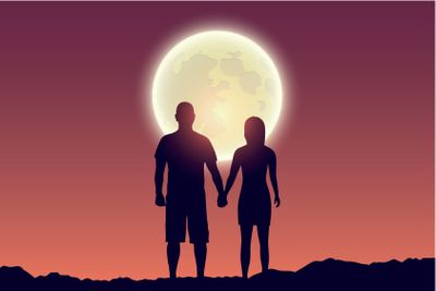 young couple looks to the full moon silhouette