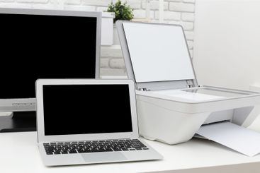 Home office setup with laptop printer and monitor in a...