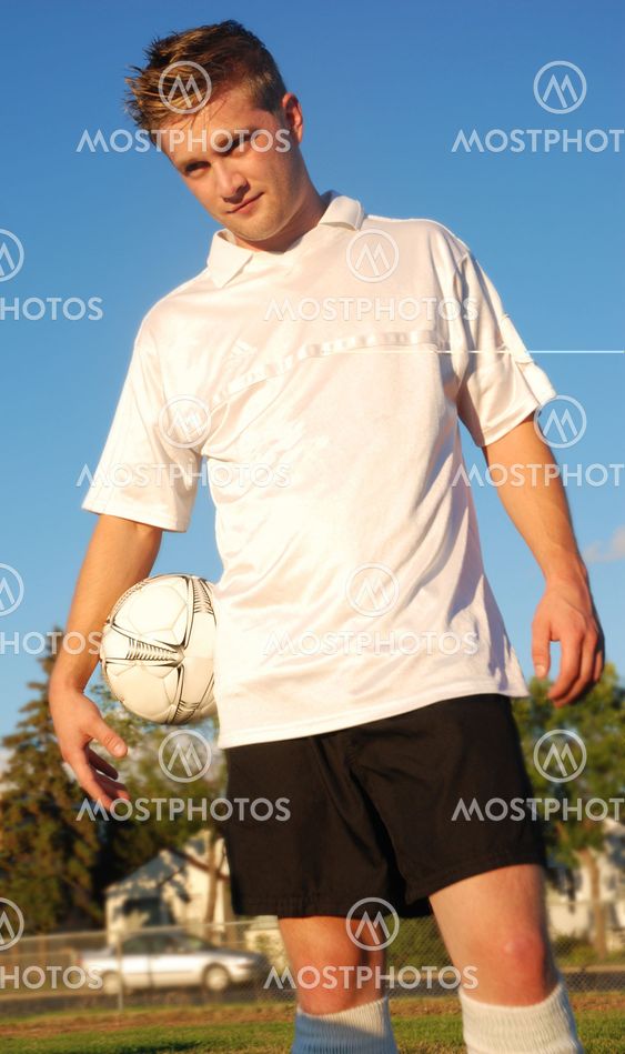 soccer/football player in a field holding a ball