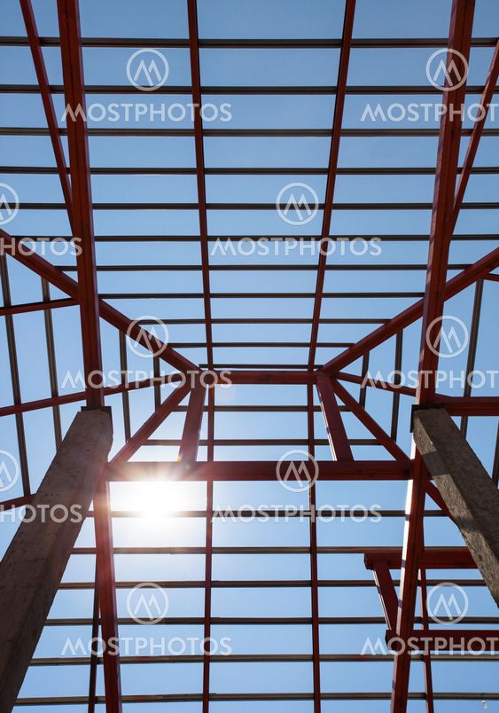 metal structure of house roof in home construction site and sun shining on blue sky use for construction business and construction industry