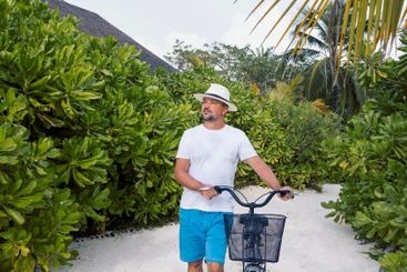A young man in casual clothes is driving a bicycle along...
