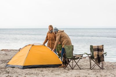 family looking at camping tent on seashore