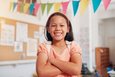 Arms crossed, student and smile with girl in classroom...