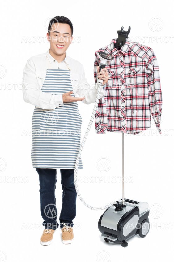 chinese young man ironing his clothes