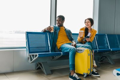happy african american couple sitting in departure lounge...