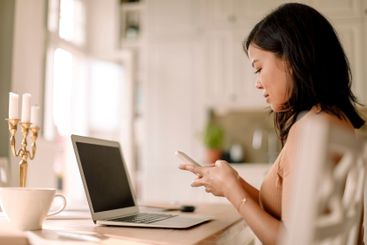 Side view of businesswoman using smart phone at dining...