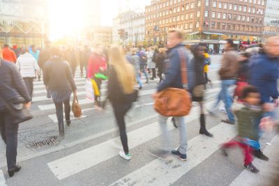 Blurred crowd of people walking on zebra crossin in...
