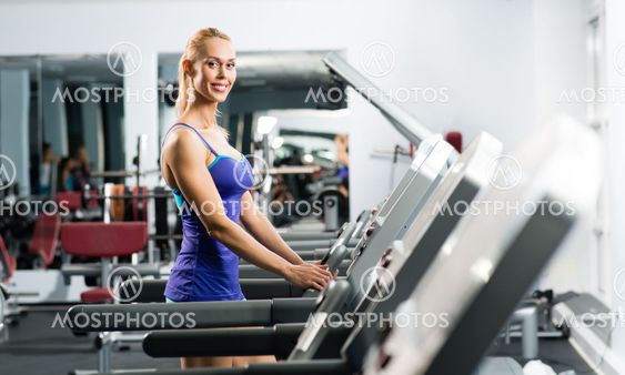 attractive young woman runs on a treadmill